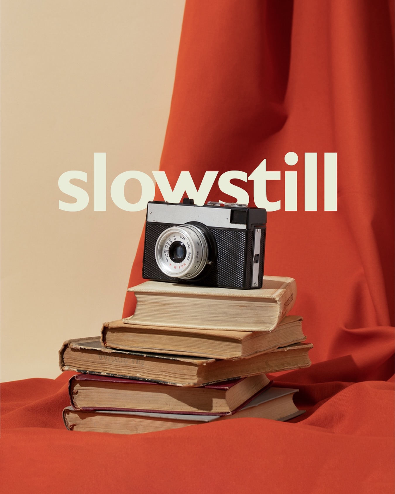 Vintage film camera on a stack of old books with the word slowstill